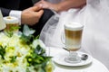 Hands of the bride and groom for a cup of coffee. Wedding bouquet on the table. Royalty Free Stock Photo