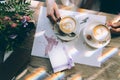 Hands of the bride and groom for a cup of coffee. Wedding bouquet on the table. Royalty Free Stock Photo