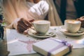 Hands of the bride and groom for a cup of coffee. Wedding bouquet on the table. Royalty Free Stock Photo