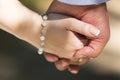 Hands of bride and groom with pearl bracelet