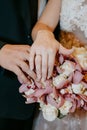Hands of the bride and groom with rings on the background of a wedding bouquet Royalty Free Stock Photo