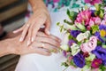 Hands of the bride and groom with rings on a beautiful wedding bouquet Royalty Free Stock Photo