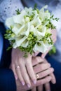 hands of bride and groom with rings. bride and groom. wedding bouquet table. bride and groom hold each other's hands. Royalty Free Stock Photo