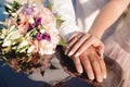 Hands of bride and groom with rings near wedding bouquet. Marriage concept Royalty Free Stock Photo