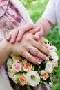 Hands of the bride and groom with rings on wedding bouquet Royalty Free Stock Photo