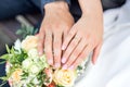 Hands of bride and groom with rings on wedding bouquet. Marriage concept Royalty Free Stock Photo