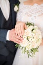 Hands of bride and groom with rings on wedding bouquet. Marriage concept Royalty Free Stock Photo