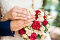 Hands of bride and groom with rings on wedding bouquet. Marriage concept Royalty Free Stock Photo