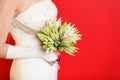 Hands of bride hold bouquet of lilies on red Royalty Free Stock Photo