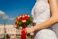 Hands of the bride holding a bouquet of red roses, the hands of a slender bride in a white dress Royalty Free Stock Photo