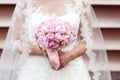 Hands of a bride holding peonies bouquet Royalty Free Stock Photo