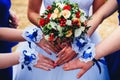 Hands bridesmaids with bracelets and bride with bouquet together