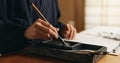 Hands, brush in ink for writing and Japanese calligraphy or ancient script for art and inkstone. Asian creativity, black Royalty Free Stock Photo