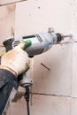 Hands of the Builder drilling the wall at the construction site Royalty Free Stock Photo