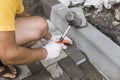 Hands of a builder in his orange gloved hands with a hammer fitting laying new exterior paving stones carefully placing Royalty Free Stock Photo