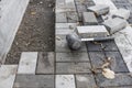 Hands of a builder in his orange gloved hands with a hammer fitting laying new exterior paving stones carefully placing Royalty Free Stock Photo