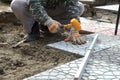 Hands of a builder laying new paving stones carefully placing on Royalty Free Stock Photo