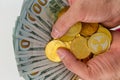 Hands with bundle of banknotes with coins