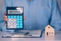 Hands of business man holding calculator for calculate refinance home and expense for loan mortgage.