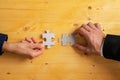 Hands of business partners matching two blank puzzle pieces Royalty Free Stock Photo