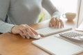 Hands of business woman using keyboard and computer. Asian woman working on desk with calculator, book bank Royalty Free Stock Photo