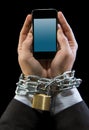 Hands of businessman addicted to work chain locked in mobile phone addiction