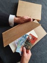 hands of a businessman with Australian money and books on the table Royalty Free Stock Photo