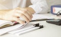 Hands of businessman hold pen for work in stacks of paper files, information search for business reports and heaps o Royalty Free Stock Photo