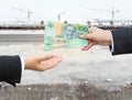 Hands of businessman passing Australian dollar (AUD) banknote. Royalty Free Stock Photo