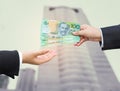 Hands of businessman passing Australian dollar (AUD) banknote. Royalty Free Stock Photo