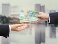 Hands of businessman passing Australian dollar (AUD) banknote. Royalty Free Stock Photo