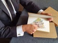 hands of a businessman with peruvian money and books on the table