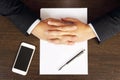 Hands of a businessman, phone, white paper on the desktop, top view Royalty Free Stock Photo