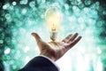 Hands of a businessman reaching to towards light bulb, business concept Royalty Free Stock Photo