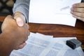 Hands of businessman shaking after to finish signing and stamp on paper document to approve business investment contract agreement Royalty Free Stock Photo