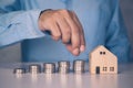 Hands of businessman and stack of coin with saving money for real estate and success.