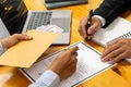 Hands of a businessman who bribed a female colleague who signed a contract in a male office offering a hundred dollar bills. Close