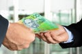 Hands of businessmen passing money, Australia dollar banknotes