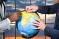 Hands of businessmen touch globe.