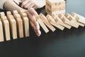 Hands of businesswoman stop block a wood game, gambling placing a wooden block. Concept Risk of management and strategy plan,