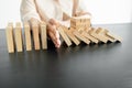 Hands of businesswoman stop block a wood game, gambling placing a wooden block. Concept Risk of management and strategy plan,