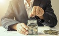 The hands of a businesswoman who put coins in a jar to save money. Royalty Free Stock Photo