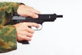 Hands in camouflage uniform reload pistol