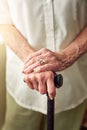 Hands, cane and closeup of senior woman with disabled injury with balance in retirement in house. Walking stick, elderly