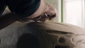 Hands of a car designer works on design details of unfinished sculpture of a car