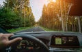 Hands of car driver on steering wheel, road trip