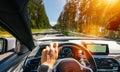 Hands of car driver on steering wheel, road trip, driving on highway road