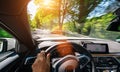 Hands of car driver on steering wheel, road trip, driving on highway road