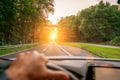 Hands of car driver on steering wheel, road trip, driving on highway road