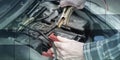 Hands of car mechanic using car battery jumper cable, geometric pattern